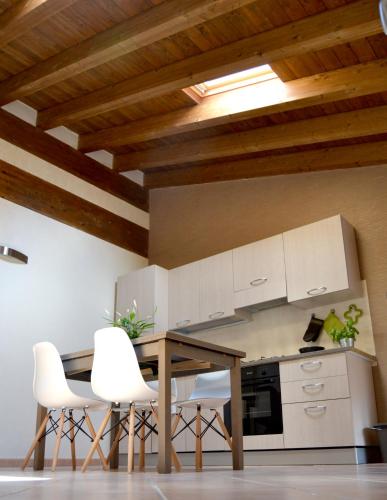 - une cuisine avec une table en bois et des chaises blanches dans l'établissement Downtown in Parma, à Parme
