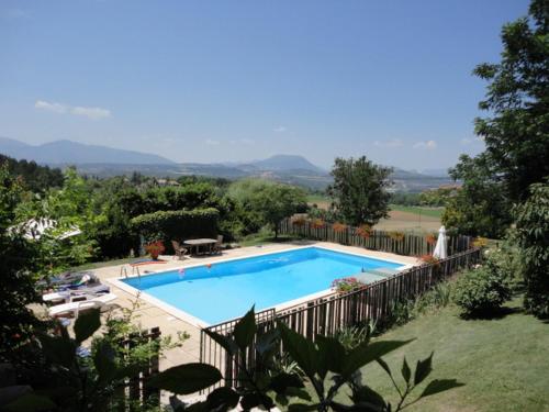 a swimming pool in a yard with a fence around it at Le Jas des Sagnières - Un Gite de Charme en Haute Provence in Sigoyer