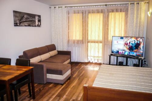 a living room with a couch and a flat screen tv at Apartament z ogródkiem w Parku Zdrojowym in Świnoujście
