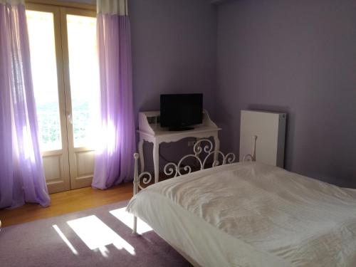 a bedroom with a bed and a television on a table at Endless Blue in Anavissos