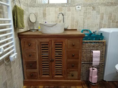 La salle de bains est pourvue d'un lavabo sur une armoire en bois. dans l'établissement Appartements équipés 1km plage, à Fos-sur-Mer