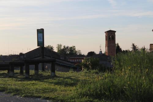 a building with a clock tower in the middle of a field at Green House in campagna in Melara
