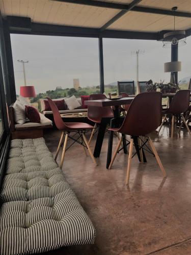a room with chairs and tables and a couch at Villa Vravrona Tower & Suites in Markopoulo