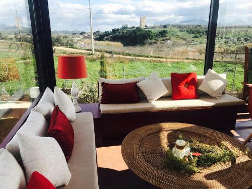 a living room with a couch and a table at Villa Vravrona Tower & Suites in Markopoulo