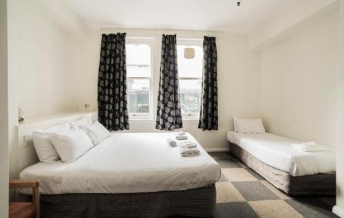 1 Schlafzimmer mit 2 Betten und einem Fenster in der Unterkunft Albion Hotel in Auckland