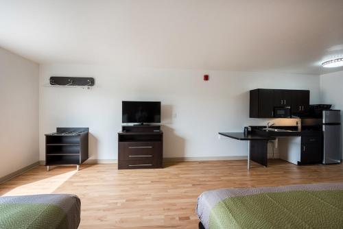 a room with two beds and a desk and a kitchen at Studio 6-Mccarran, NV - Sparks - Tahoe - Reno Industrial Center in Clark