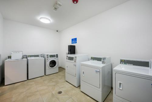 a laundry room with four washing machines and a washer and dryer at Studio 6-Mccarran, NV - Sparks - Tahoe - Reno Industrial Center in Clark