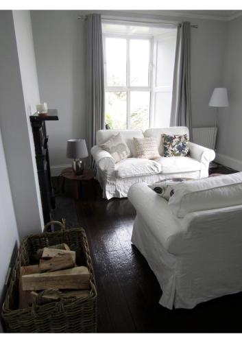 a living room with two white couches and a window at Berry Lodge Country House in Spanish Point