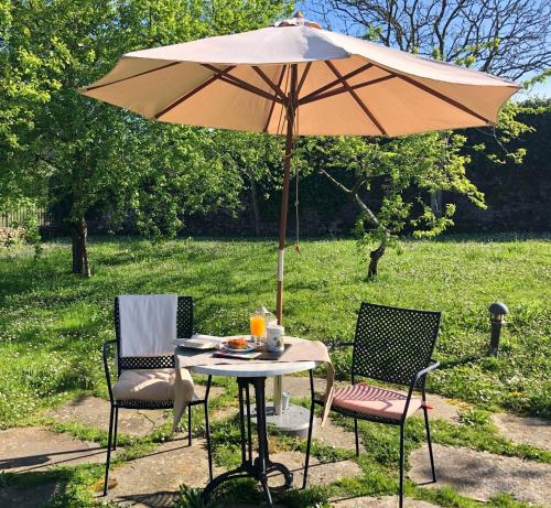 a table and two chairs under an umbrella at Hotel Rural Casona Trabadelo in Vegadeo
