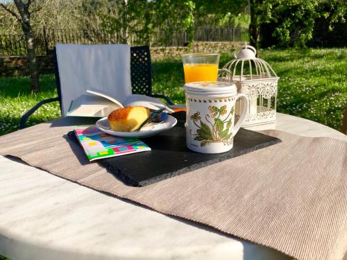 a table with a plate of food and a cup of orange juice at Hotel Rural Casona Trabadelo in Vegadeo