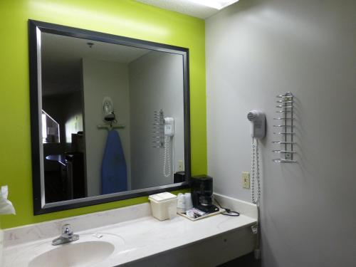 ein Bad mit einem Waschbecken und einem Spiegel in der Unterkunft Coach Inn - Summerville in Summerville