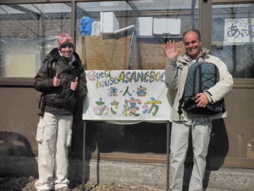 two men are standing next to a sign at Traveler's Inn Asanebo in Teshikaga