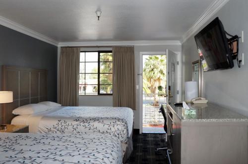 Habitación de hotel con 2 camas y ventana en Americas Best Value Inn - Milpitas, en Milpitas