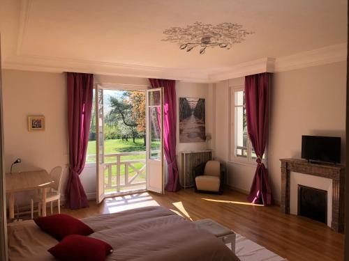 a bedroom with a bed and a fireplace and a window at La villa rochette in Forges-les-Bains