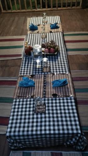 a black and white checkered table with plates of food at ESA di Kubu Homestay in Singaraja
