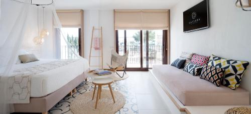 salon z łóżkiem i kanapą w obiekcie Gatzara Suites Santa Gertrudis w mieście Santa Gertrudis de Fruitera