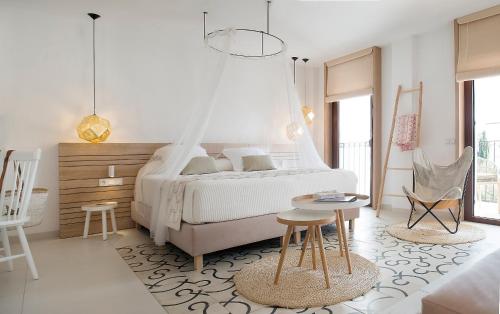 sypialnia z łóżkiem, stołem i krzesłami w obiekcie Gatzara Suites Santa Gertrudis w mieście Santa Gertrudis de Fruitera