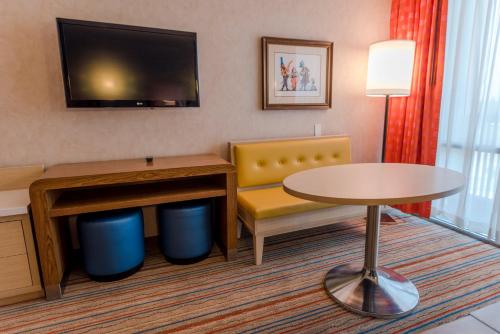 a hotel room with a table and a chair and a desk at Howard Johnson by Wyndham Anaheim Hotel & Water Playground in Anaheim