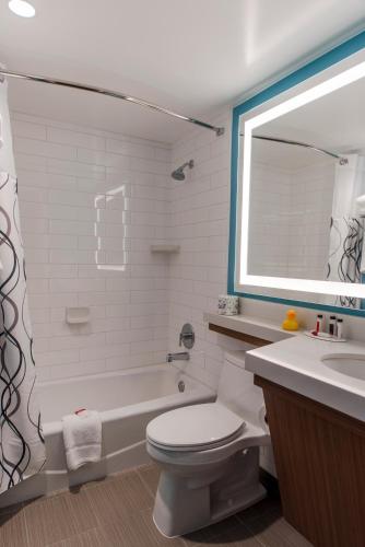 a bathroom with a tub and a toilet and a sink at Howard Johnson by Wyndham Anaheim Hotel & Water Playground in Anaheim