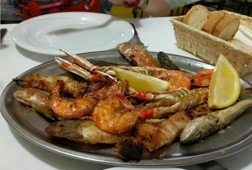 a plate of shrimp and other food on a table at B&B AL MARE in Porto San Giorgio