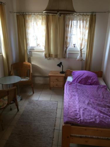 a bedroom with a bed and a table and windows at Biogut Evensen in Evensen