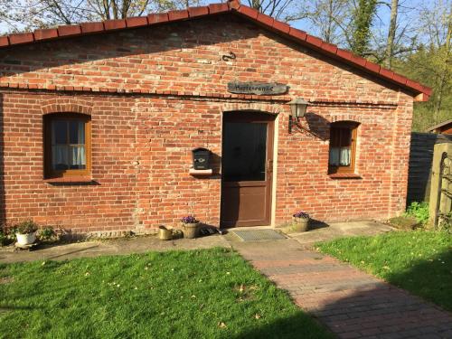 a brick building with a door and a grass yard at Biogut Evensen in Evensen