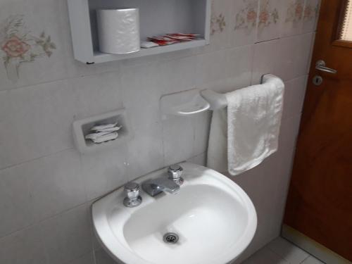 a bathroom with a white sink and a toilet at Departamento Maipú in Paraná
