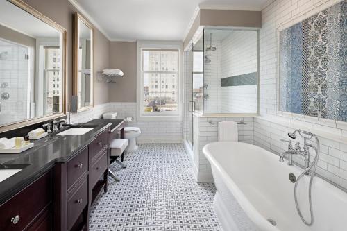 a bathroom with two sinks and a tub and a shower at The Hancock Hotel in Findlay