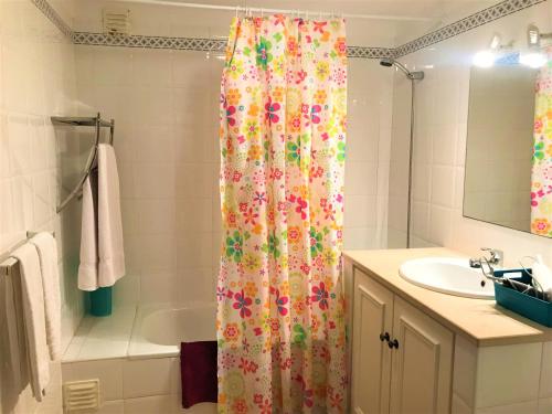 un bagno con tenda da doccia e lavandino di Casas da Vila a Luz