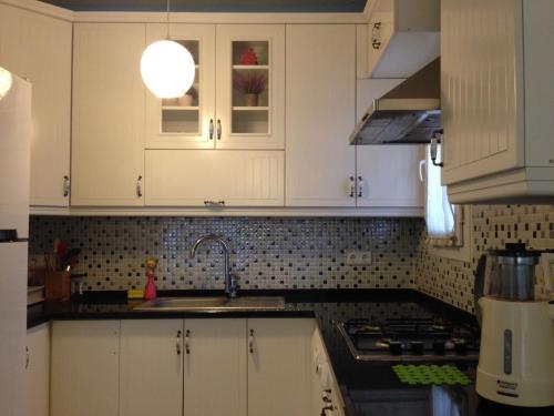 a kitchen with white cabinets and a sink at Zübeyde Hanım Homes in Izmir