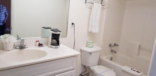 a white bathroom with a sink and a toilet at Night Inn in Globe