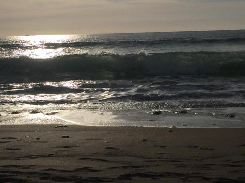 a view of the ocean with the sun shining on the beach at Berry Lodge Country House in Spanish Point