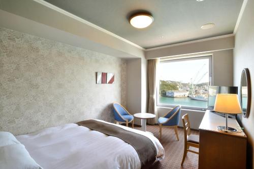 een hotelkamer met een bed en een raam bij Green Hill Hotel Onomichi in Onomichi