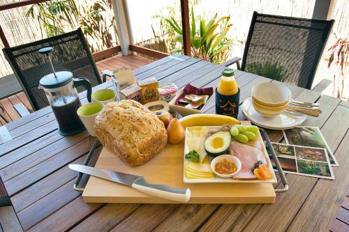 a tray of breakfast food on a wooden table at Witches Falls Cottages in Mount Tamborine