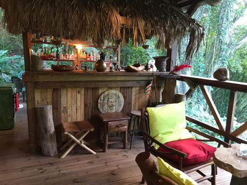 a bar in a room with a bench and a chair at Martinique Treehouse in Canton Suisse