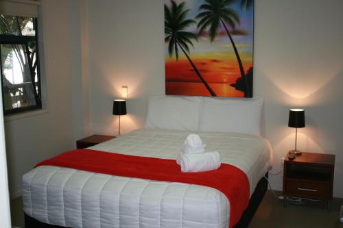 Un dormitorio con una cama grande con una toalla. en Atlas Suites and Apartments, en Mount Maunganui