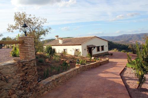 una casa con una pared de piedra junto a una entrada en Finca El Chaparral, en Cortelazor