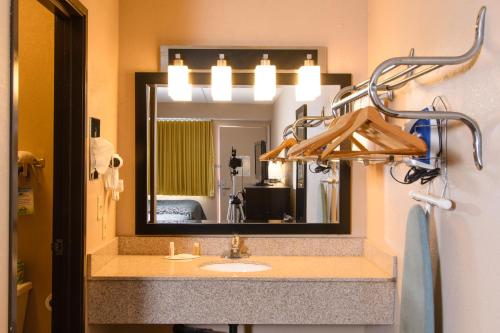 La salle de bains est pourvue d'un lavabo et d'un miroir. dans l'établissement Days Inn by Wyndham Pittsburgh-Harmarville, à Harmarville