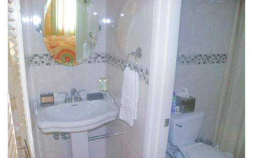 a white bathroom with a sink and a toilet at Sand Dreams at Turtle Towers in Ocho Rios