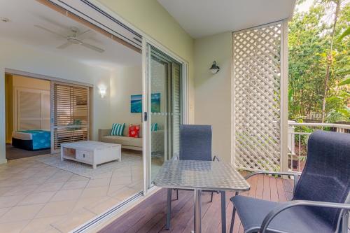 
a living room filled with furniture and a window at Macrossan House Boutique Holiday Apartments in Port Douglas

