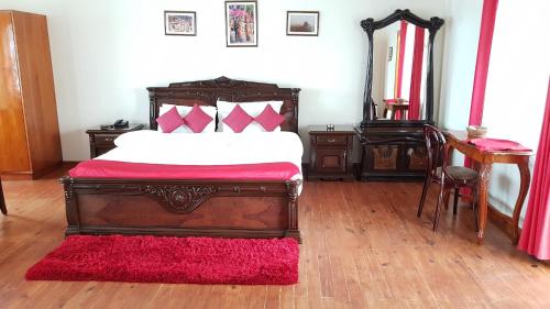 a room with a bed, chair, lamp and a dresser at Hotel Woodland Hill Stay in Shillong