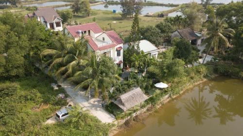 an aerial view of a house next to a river at Tra Que Riverside Homestay in Hoi An