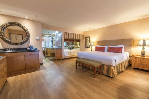 a bedroom with a large bed and a bathroom at Best Western Plus Las Brisas Hotel in Palm Springs