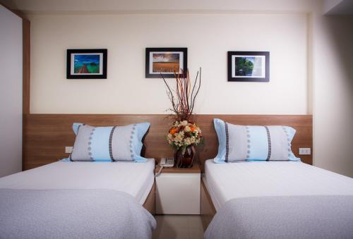 dos camas sentadas una al lado de la otra en una habitación en KC Place Srinakarin, en Bangna
