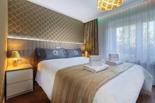 ein Schlafzimmer mit einem Bett mit zwei Handtüchern darauf in der Unterkunft The Queen Luxury Apartments - Villa Vinicia in Luxemburg (Stadt)