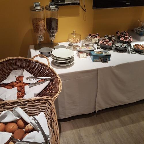 Una mesa con platos y una cesta de comida encima. en Logis Hôtel La Magnanerie - Côté Bistro, en Aubignosc