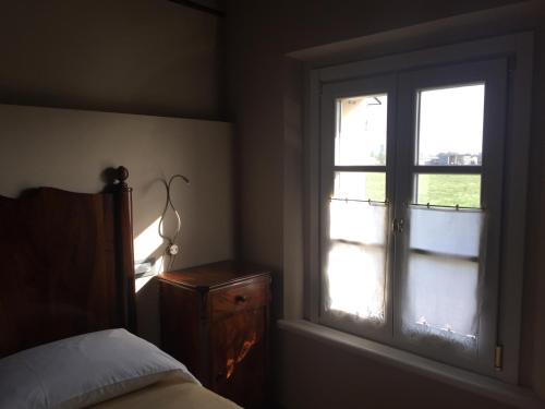 a bedroom with a window and a bed and a dresser at Corte Motte in Pegognaga