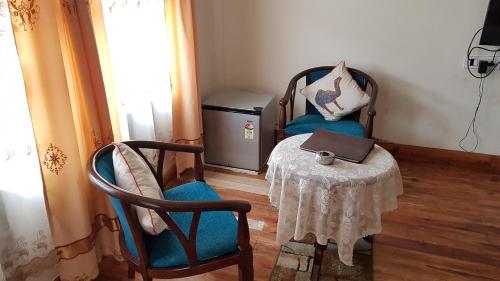 a room with two chairs and a table with a laptop at Woodland Hill Stay in Shillong