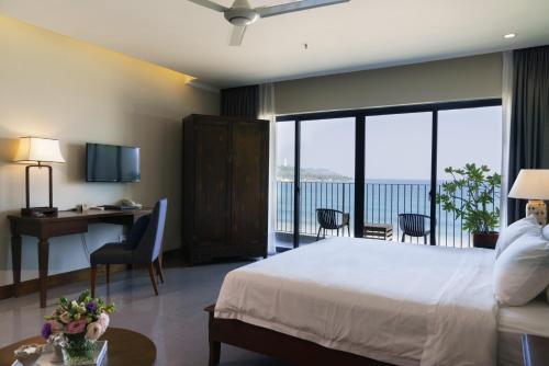 a hotel room with a bed and a view of the ocean at Dan Oasis Hotel and Apartment in Danang