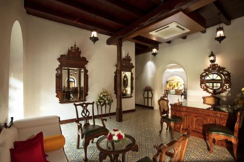 a living room with a couch and a table and chairs at Forte Kochi in Cochin